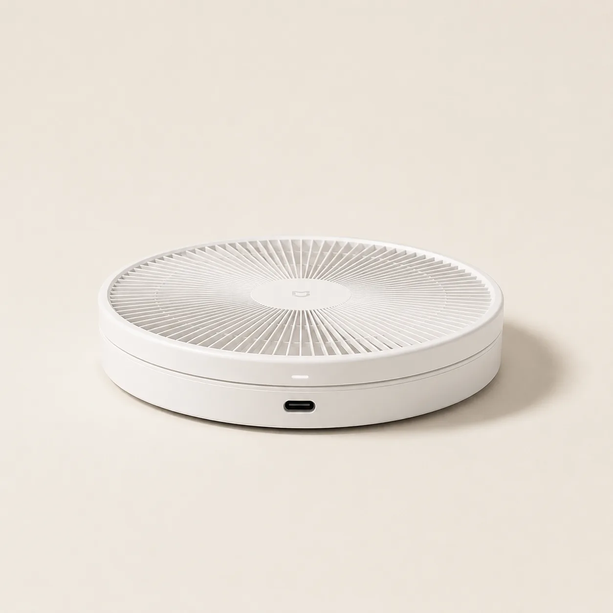 Ventilateur sur pied Aermio entièrement replié à plat, vu de trois quarts, son port de charge USB-C visible sur la tranche du socle