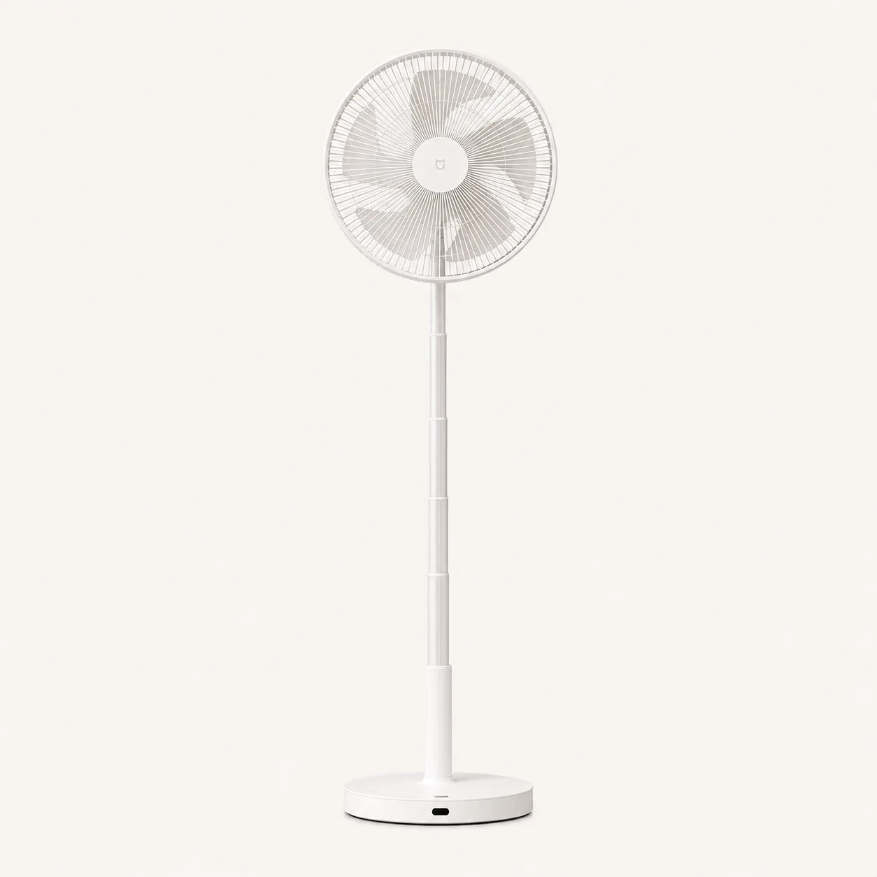 Ventilateur sur pied blanc entièrement déployé, sur fond crème uni