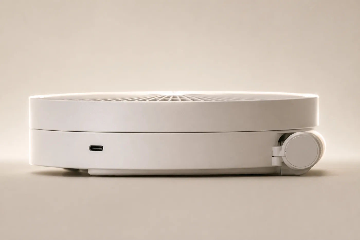 Ventilateur replié vu de profil, réduit à son socle et à sa tête posée à plat