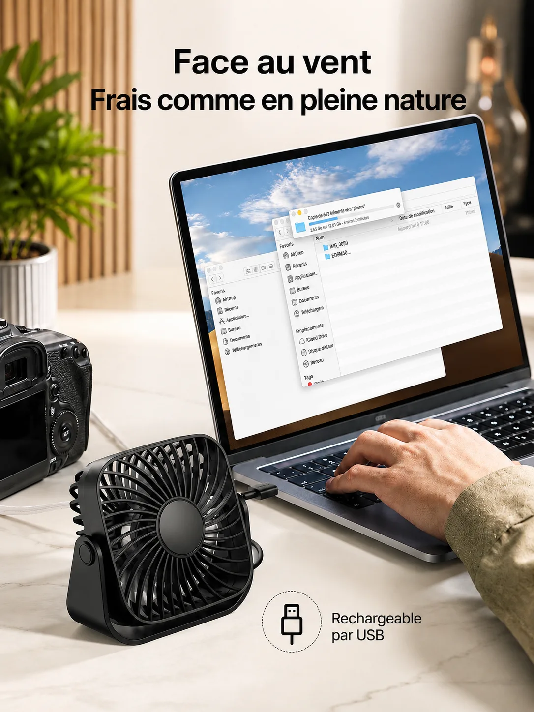 Le petit ventilateur noir posé devant un ordinateur portable sur un bureau